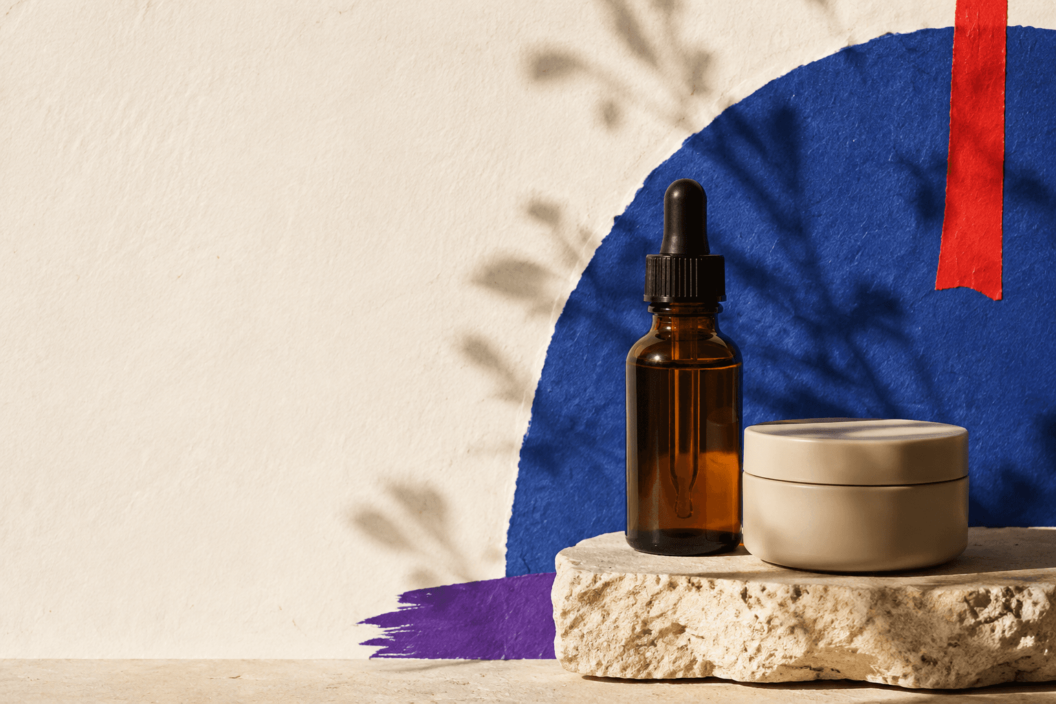 Sérum ambré et pot crème dans une composition de papier bleu, rouge et violet